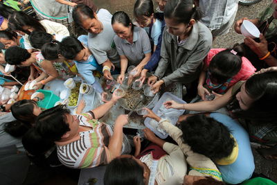 Directly above shot of man serving drink to people