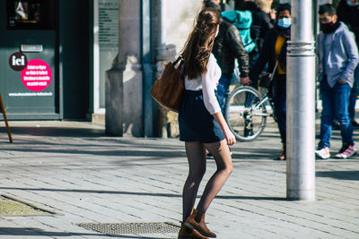 Full length of woman walking on street in city