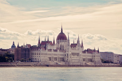 Buildings in city against cloudy sky