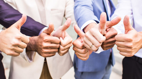 Midsection of business people stacking hands