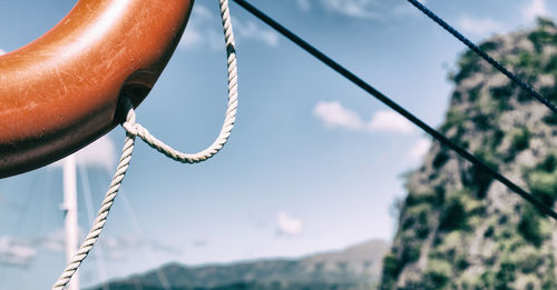 Low angle view of chain swing against sky