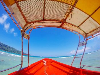 Boat sailing in sea against blue sky