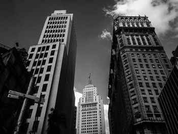 Low angle view of buildings against cloudy sky