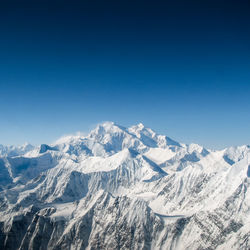 Scenic view of snowcapped mountains against clear blue sky