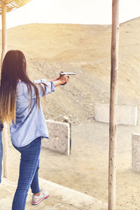 Woman releasing stress, instructor helping woman with gun