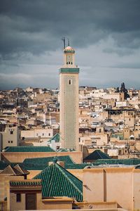 View of cityscape against cloudy sky