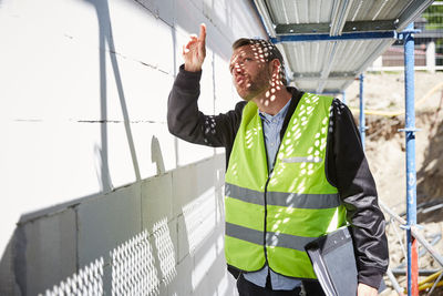 Architect with file analyzing at construction site