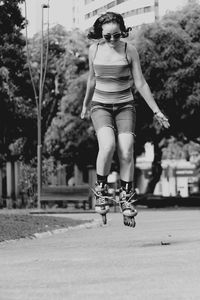 Full length of woman jumping while inline skating on street