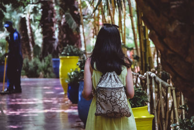 Rear view of woman standing amidst plants