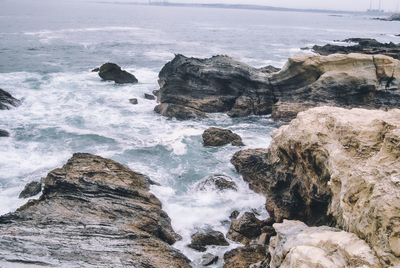 Scenic view of rocks in sea against sky