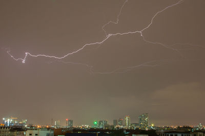 Low angle view of illuminated cityscape against sky at night