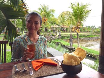 Portrait of smiling young woman drinking water