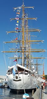 Sailboats moored in sea against clear blue sky