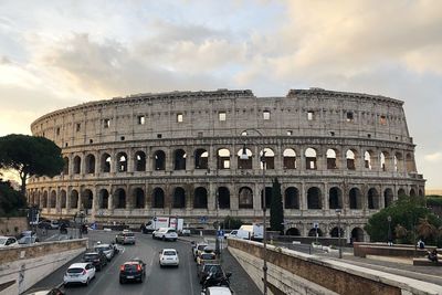 Cars on road against colosseum