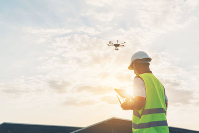 Low angle view of man standing by airplane against sky