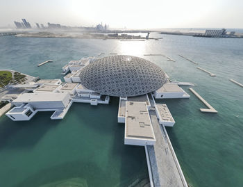 Aerial view of the louvre museum in abu dhabi at the golden hour