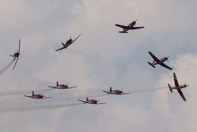 Low angle view of fighter planes flying against sky