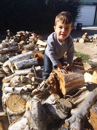 Portrait of boy standing on logs