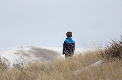 Rear view of boy standing on grass