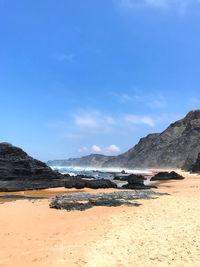 Scenic view of beach against blue sky