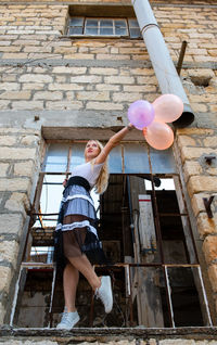 Low angle view of woman standing against wall