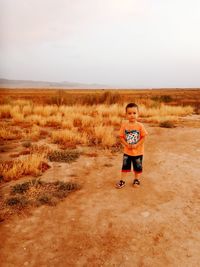 Full length portrait of man on field against sky