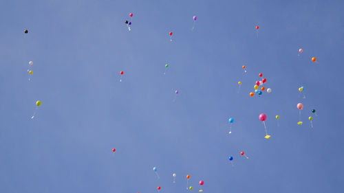 Low angle view of balloons against blue sky