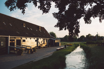 Canal by building against sky