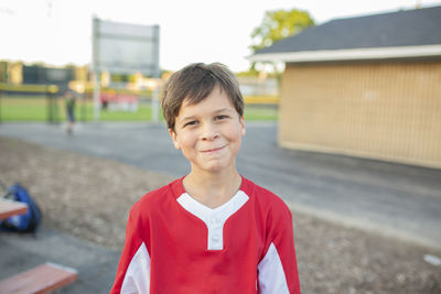 Portrait of smiling baseball player standing on playing field