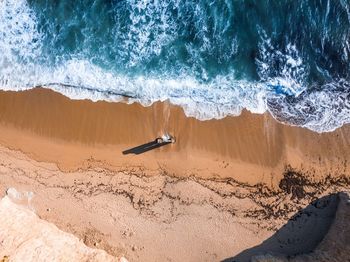 High angle view of surf on shore at beach