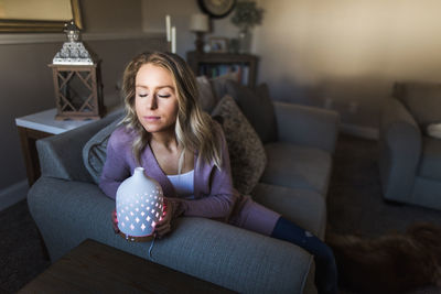 Portrait of girl sitting on sofa at home