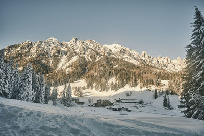 Snow covered landscape against clear sky