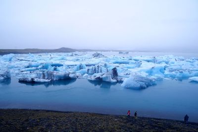 Icebergs in sea against sky during winter