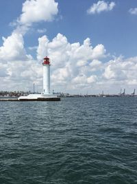 Lighthouse by sea against sky