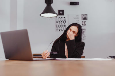 Portrait of woman using laptop on table
