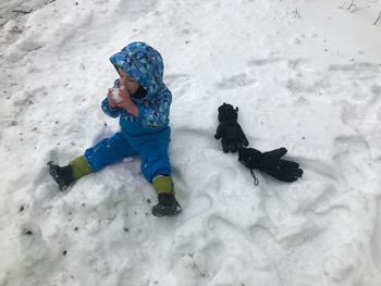 High angle view of girl playing on snow covered land