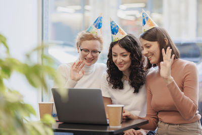 Friends using laptop while sitting at office