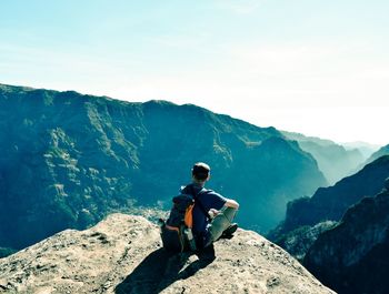 Full length of man looking at mountains against sky