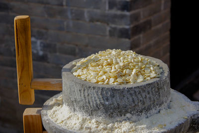 Close-up of raw food on stone grinder against wall