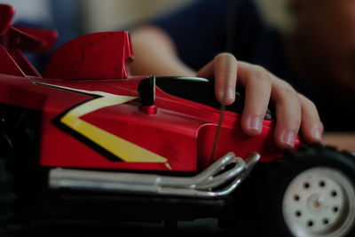 Cropped hand of child holding toy car at home