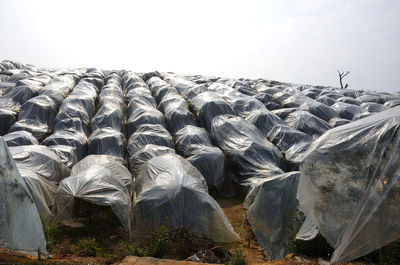 Stack of stones on field against sky