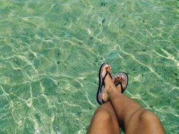 Low section of woman sitting over sea