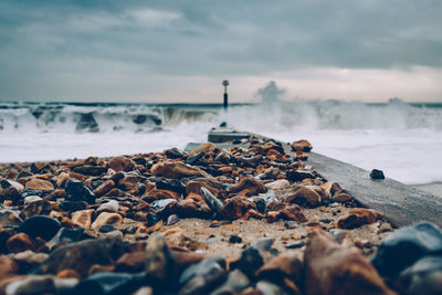 Pebbles on beach against sky