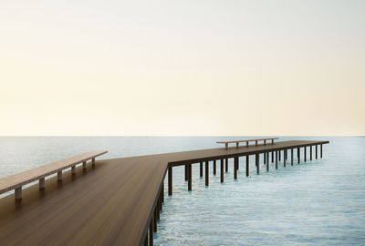 Wooden pier in sea against sky