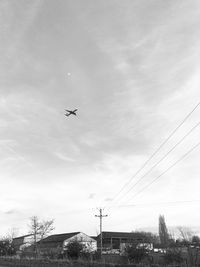 Low angle view of airplane flying against sky