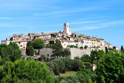 Buildings in city against blue sky