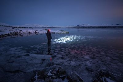 Man standing on snow covered land against sky