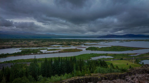 Scenic view of landscape against storm clouds