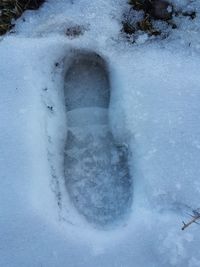 High angle view of footprints on snow covered field