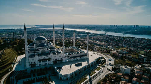 High angle view of city by sea against sky